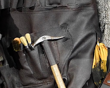 Modische zwarte werkschort met gereedschap als symbool van workwear en ambacht